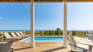 A wooden deck with lounge chairs and a pool, overlooking a clear blue sky and ocean. - Monterey Oceanfront Beach House (Port St. Joe)