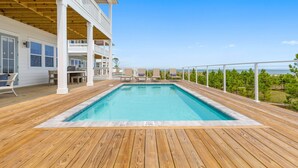 A wooden deck with a swimming pool, outdoor seating, and a view of the ocean. - Killarney Oceanfront Beach House Summer (Port St. Joe)