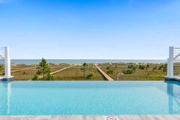 Une piscine d’un bleu éclatant, avec vue sur la plage et l’océan.