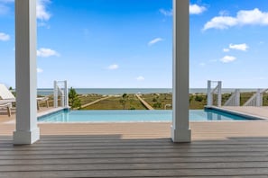 A wooden deck with a pool and a view of the ocean. - Frazer Oceanfront Beach House with Elevated Infinity Pool! (Premier Bella Proper (Port St. Joe)