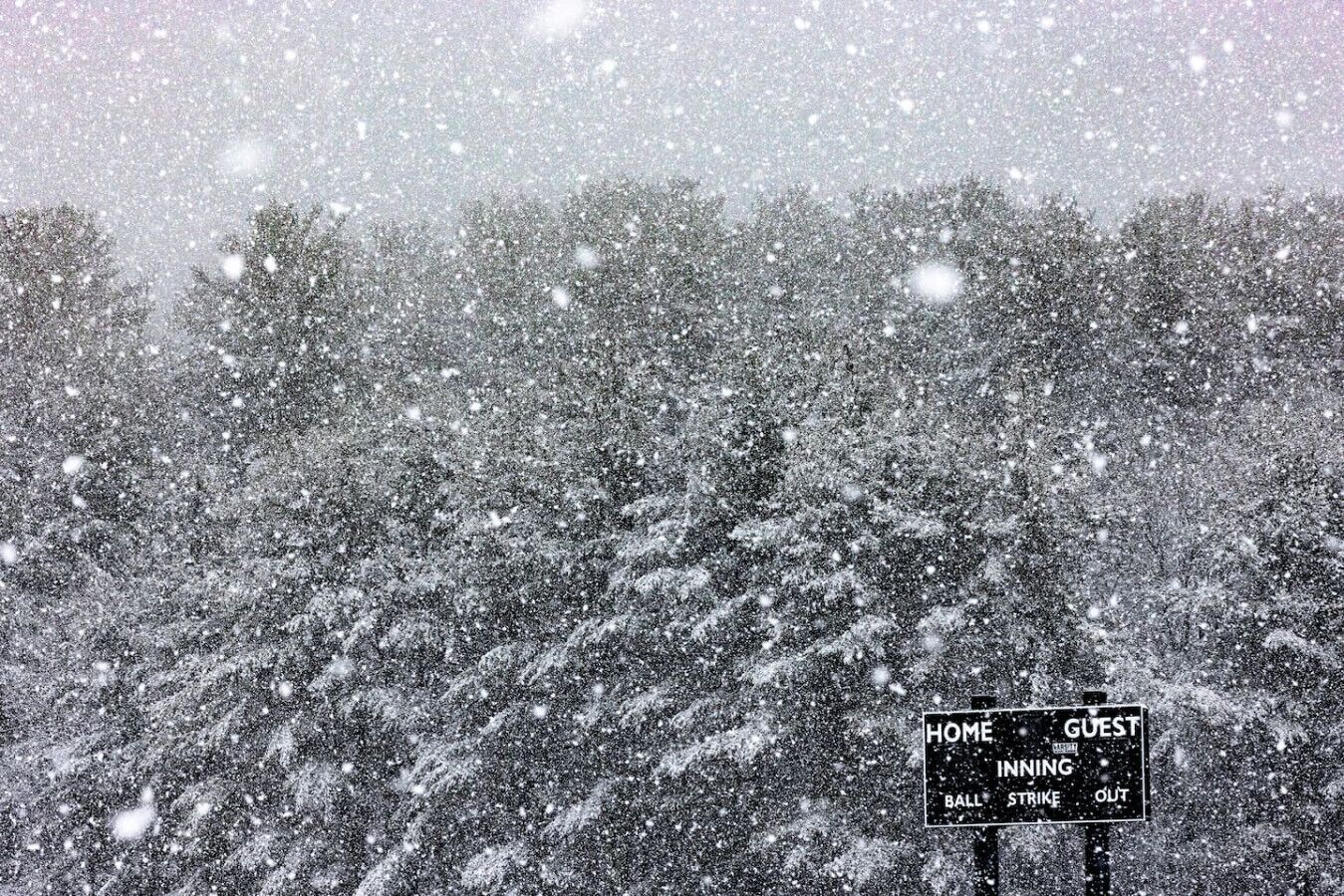 Paisaje nevado con un cartel que indica 'HOME INNING BALL STRIKE OUT'.