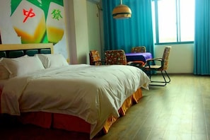 A hotel room with a bed, a table, chairs, and a window with curtains.