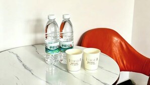 A table with two water bottles and two mugs on a marble surface. - Fenglin Art Hotel (Pingle)