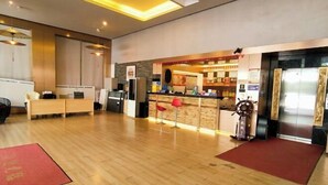 A hotel lobby with a reception desk, a bar area, and a seating area. - Fenglin Art Hotel (Pingle)