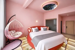 A bedroom with a bed, a hanging chair, and a circular ceiling light.