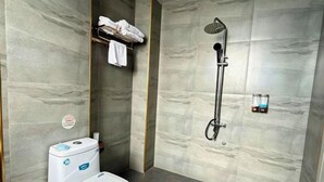 A modern bathroom with a toilet, a shower, and a towel rack. - Fenglin Art Hotel (Pingle)