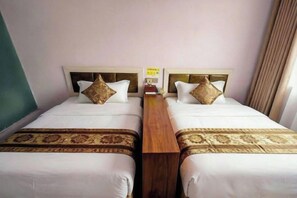 A hotel room with two beds, each with a headboard, a wooden nightstand, and a bedspread. - Fenglin Art Hotel (Pingle)