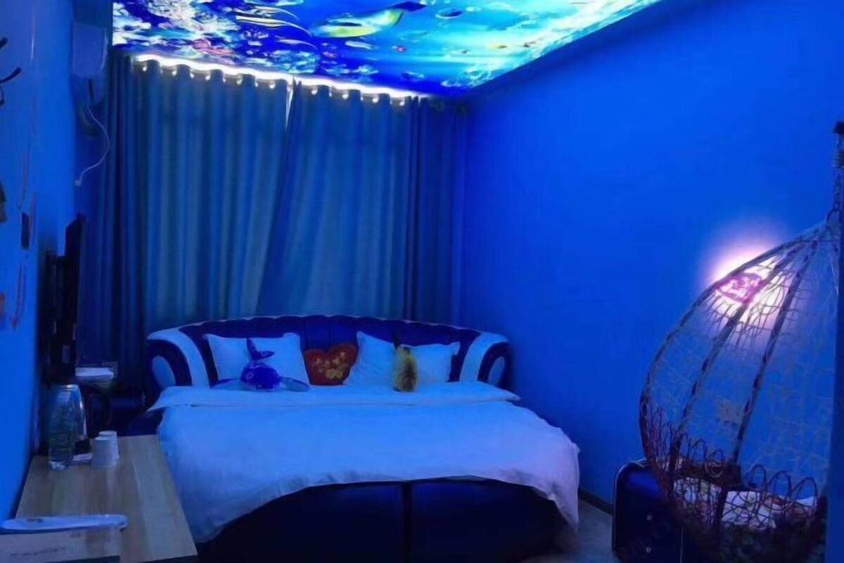 A room with a bed, a hanging chair, and a curtain.