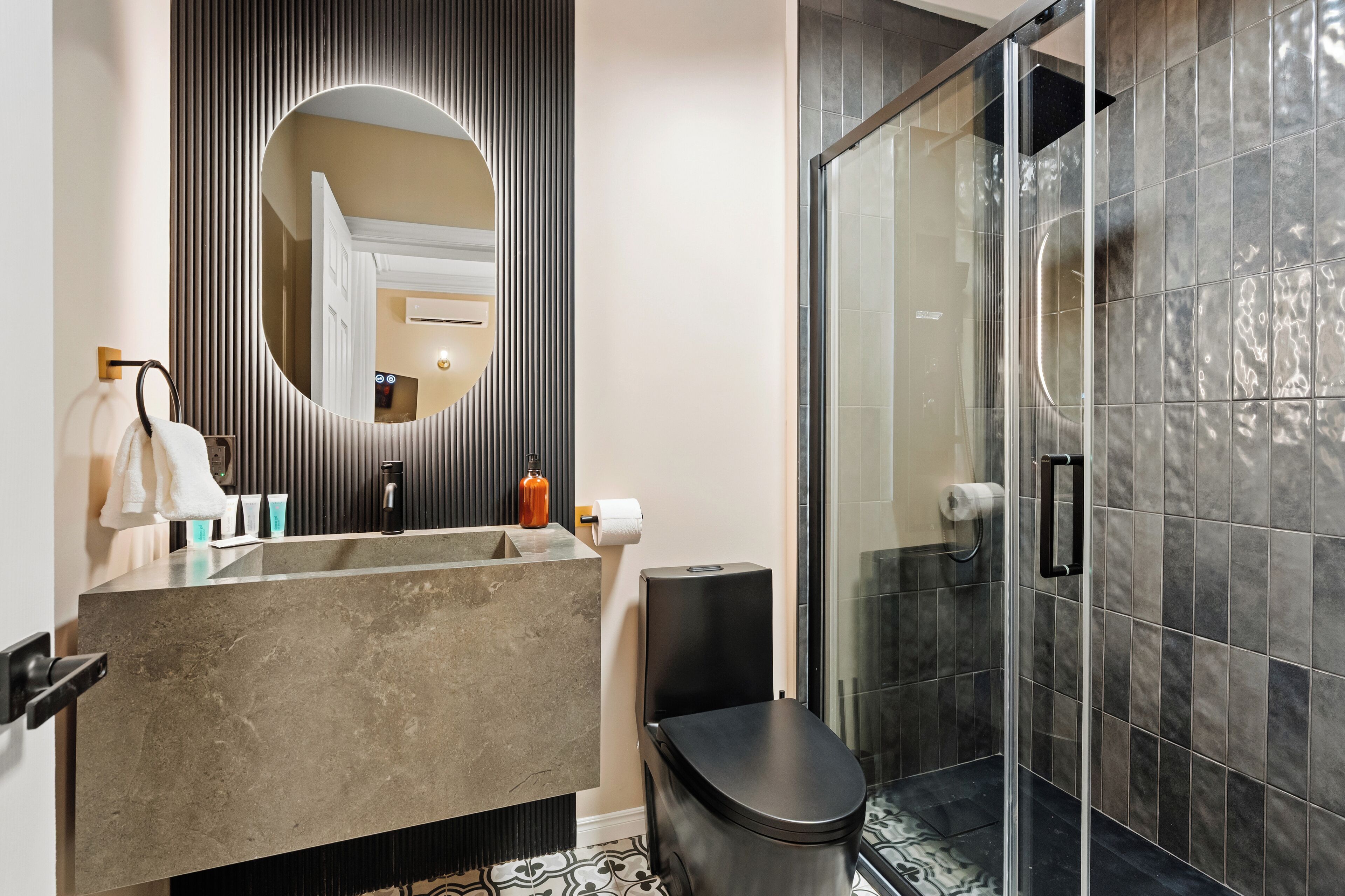 Ein modernes Badezimmer mit großem Spiegel, Toilette und Duschbereich.