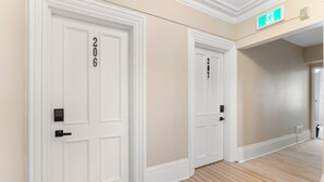 Un pasillo con dos puertas blancas, cada una con un número encima.