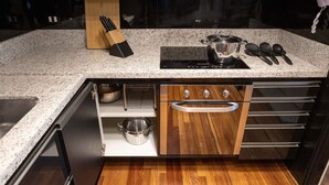 Una cocina con encimera de granito, horno integrado y armarios de madera.