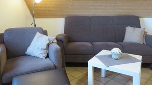 Un salon avec un canapé en cuir marron, une table basse blanche et une lampe.