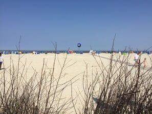 Ein Strand mit Zelten und Menschen.