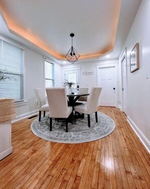 Cozy dining area with a round table and four chairs, set on a patterned rug.
