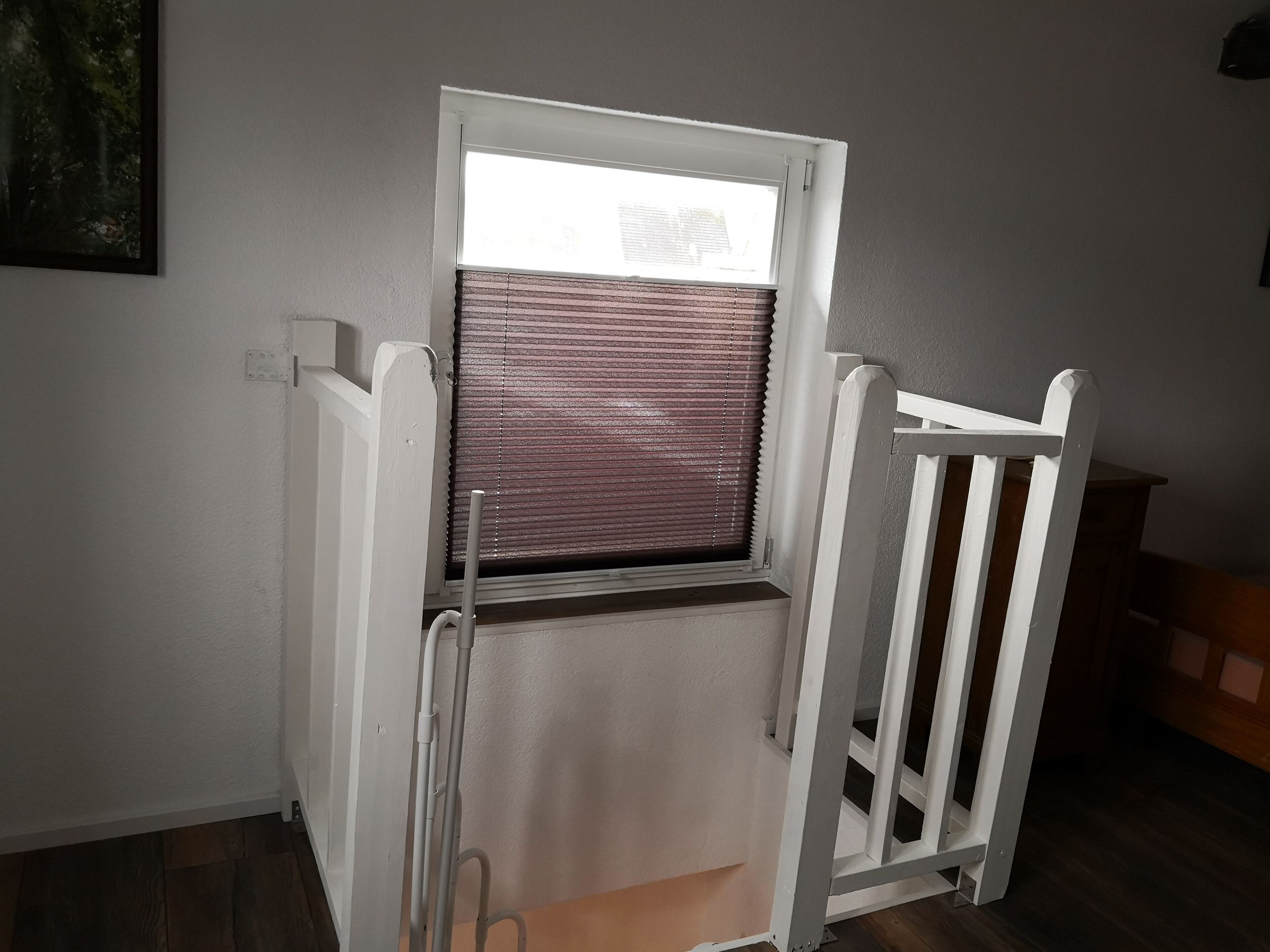 A room with a window, a white radiator, and a white chair.