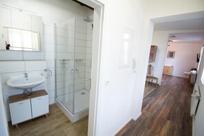 A bathroom with a sink, mirror, and shower. - Lovingly furnished apartment Alsfeld (Alsfeld)