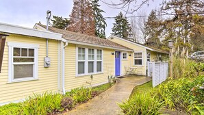 A yellow single-story house with a blue front door, a small porch, and a concrete pathway leading to the entrance. - Bainbridge Island Abode < 1 Mi to Winslow! (Bainbridge Island)