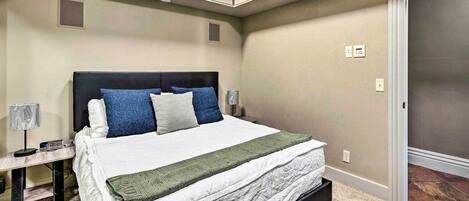 A bedroom with a bed, bedside tables, a lamp, and built-in cabinets.