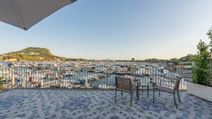 A terrace with a tiled floor, a metal railing, and a view of a marina with boats. - Baia Flegrea Meublè - Deluxe Suite with terrace (Bacoli)