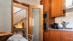 A modern kitchen with wooden cabinets, a stainless steel microwave, and a coffee maker. - Hali Red Villa, Olhos de Água, Algarve (Albufeira)