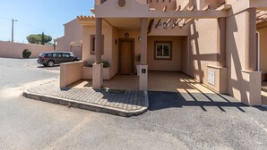 A modern building with a beige facade, a covered entrance, and a car parked in front. - Hali Red Villa, Olhos de Água, Algarve (Albufeira)