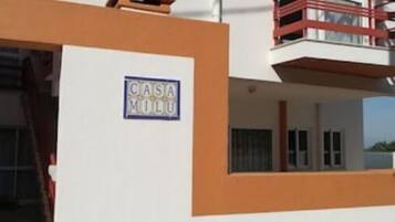 CASA MILO features a modern architectural style with a flat roof and a balcony.
