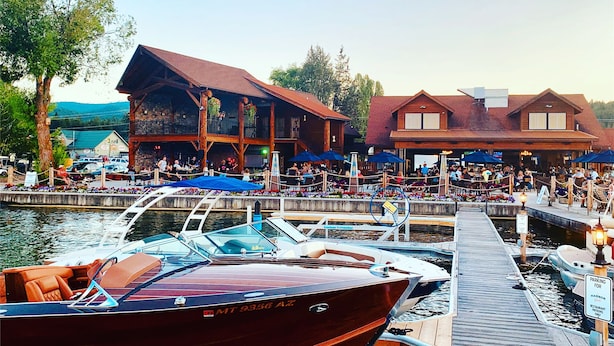 Ein Restaurant am Wasserufer mit Außenbereich und angemeldeten Booten.