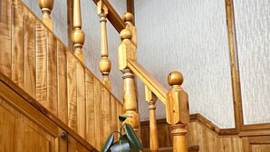 Un escalier en bois avec un pot de fleurs à sa base.