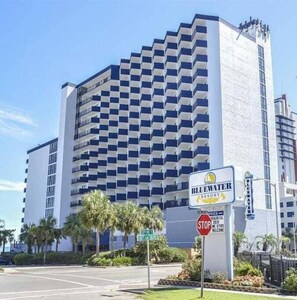 Un hôtel de grande hauteur au design moderne, avec une enseigne bien visible indiquant « Bluewater Resort ».