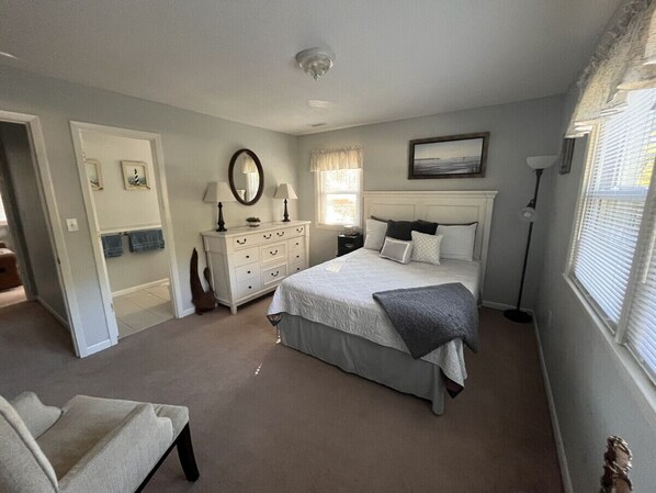 A bedroom with a bed, dresser, and a window with blinds. - Driftwood Suite . Close to CCU. 1bd/1 ba Apartment (Conway)