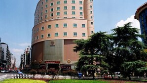 A multi-story hotel with a curved facade, multiple windows, and a large entrance. - Shen Long Mei Du Hotel (Hengyang)