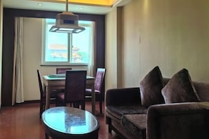 Una sala de estar con una mesa redonda de vidrio, un sofá y un comedor con sillas y una mesa.