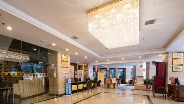 A hotel lobby with a large chandelier, reception desk, and a glass storefront. - Shen Long Mei Du Hotel (Hengyang)