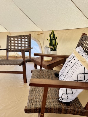 Relax in a serene space with a seating area featuring two chairs and a table, accompanied by a potted plant.