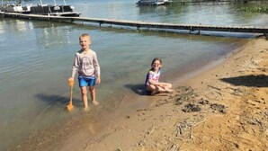 Two children near a lake with boats docked in the background. - Family Legacy Resort, Making great family memories (Allegan)