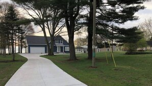 A suburban street with a sidewalk leading to a two-story house with a garage. - Family Legacy Resort, Making great family memories (Allegan)