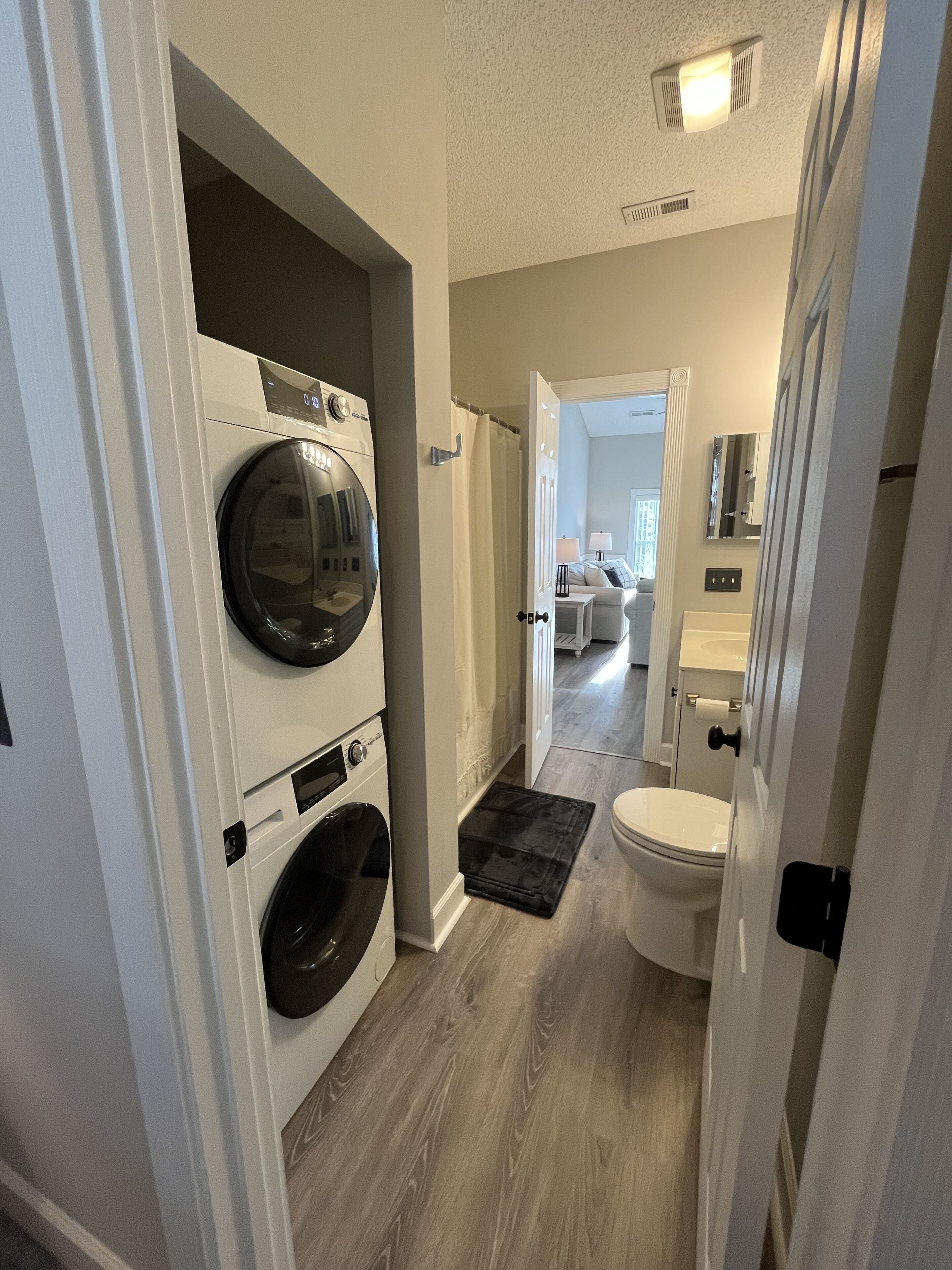 Un cuarto de lavado con lavadora, secadora y un inodoro.