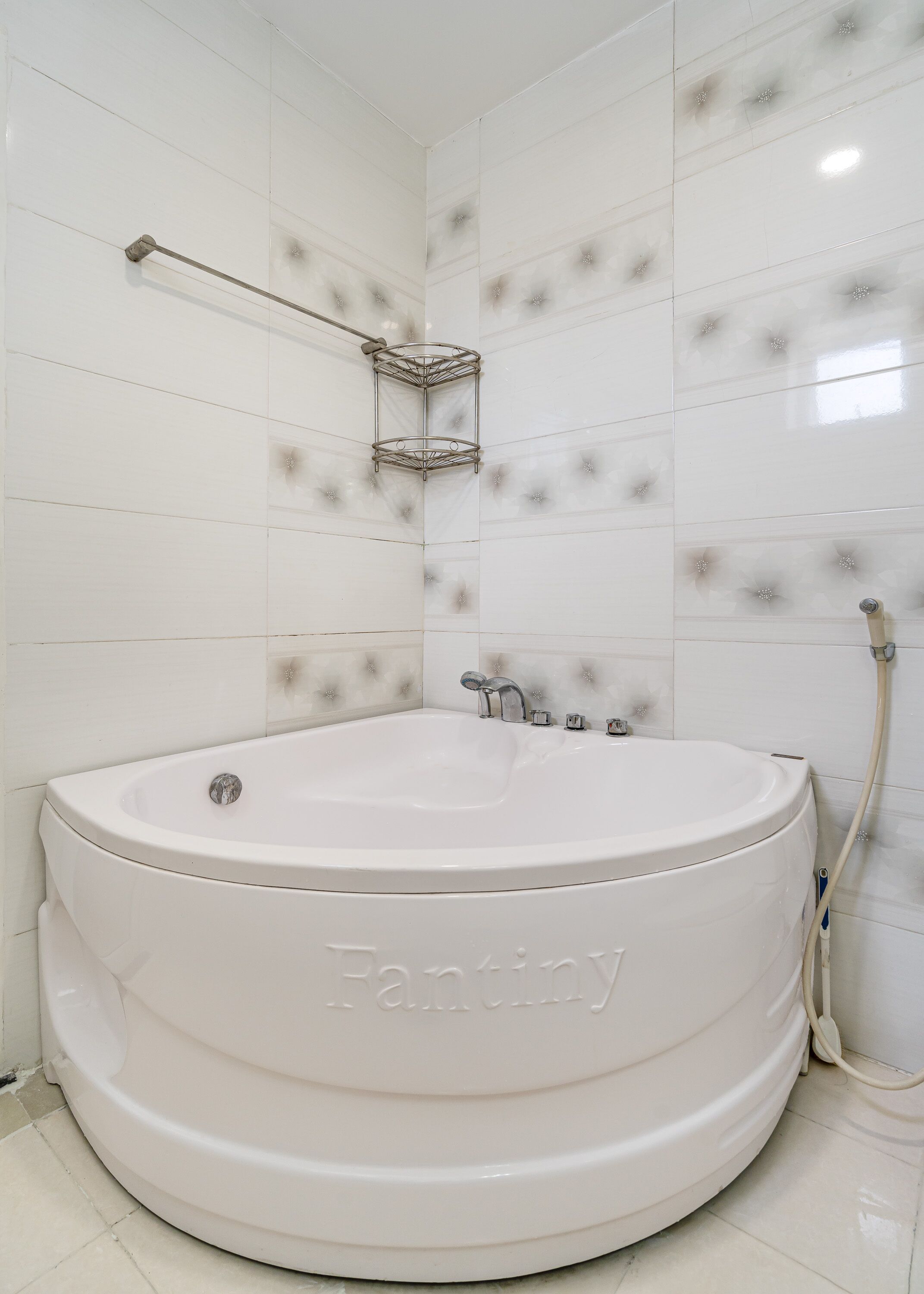 A large, round bathtub labeled 'Fantiny' in a bathroom with white tiled walls and a corner shower area.