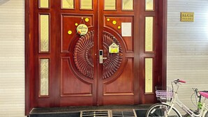 A wooden double door with decorative elements and a 'Happy New Year 2023' sign above it. - WE HOME Japan Town (Ho Chi Minh City)