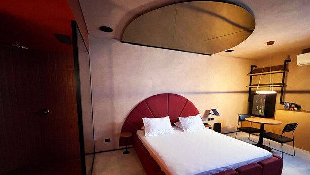 Habitación de hotel moderna con una cama grande, un escritorio y una silla.