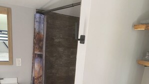 A bathroom with a wooden vanity, a toilet, and a shower curtain with a nature scene. - Nature Escape - studio in the forest (Middletown)