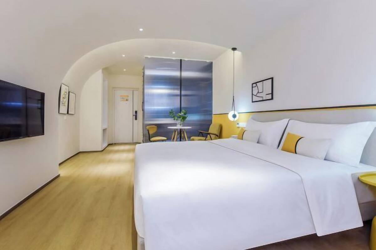 Una habitació d'hotel amb un llit, una televisió, un escriptori i una cadira.