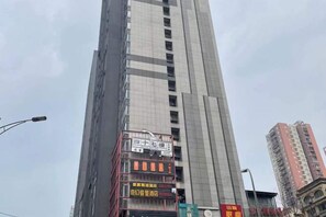 A tall building with multiple advertisements on its facade. - Chongqing Jingmu Select Hotel (Guanyin Bridge Ninth Street) (Chongqing)