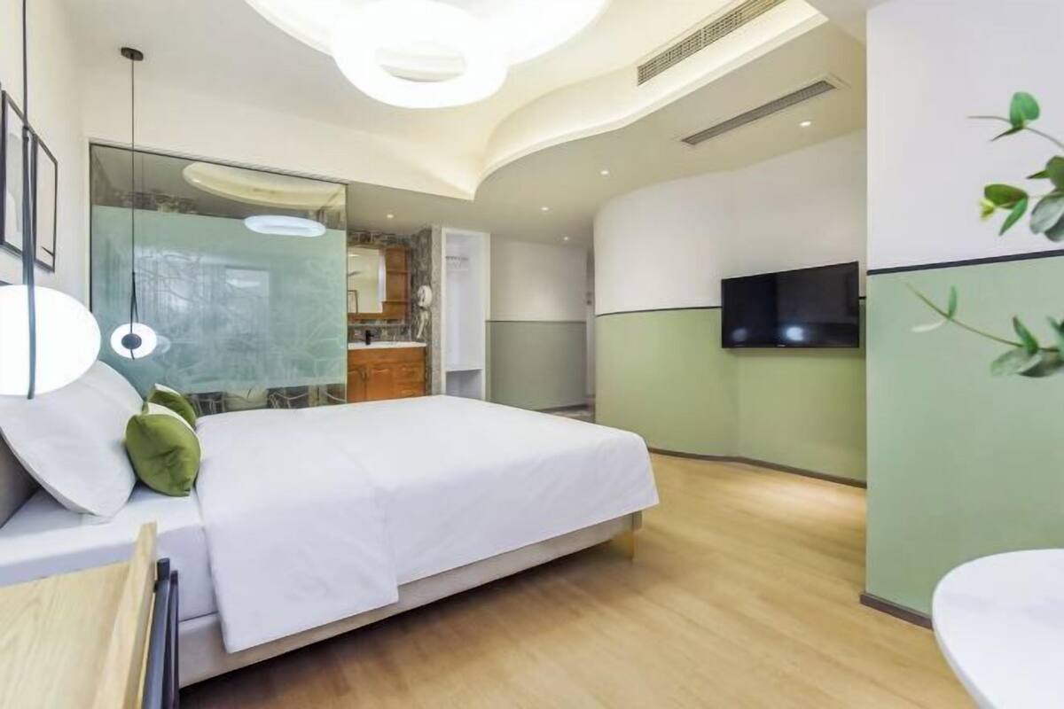 Habitació d'hotel moderna amb un llit, una televisió i un bany.