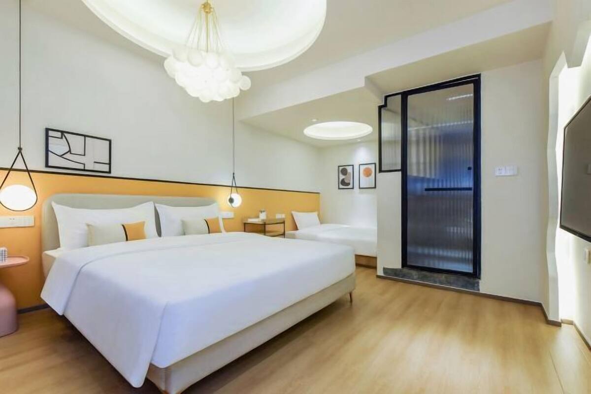 Habitació d'hotel moderna amb un llit gran, un escriptori, una cadira i una televisió.