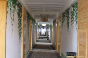 Un largo pasillo con paredes de madera y plantas colgantes.