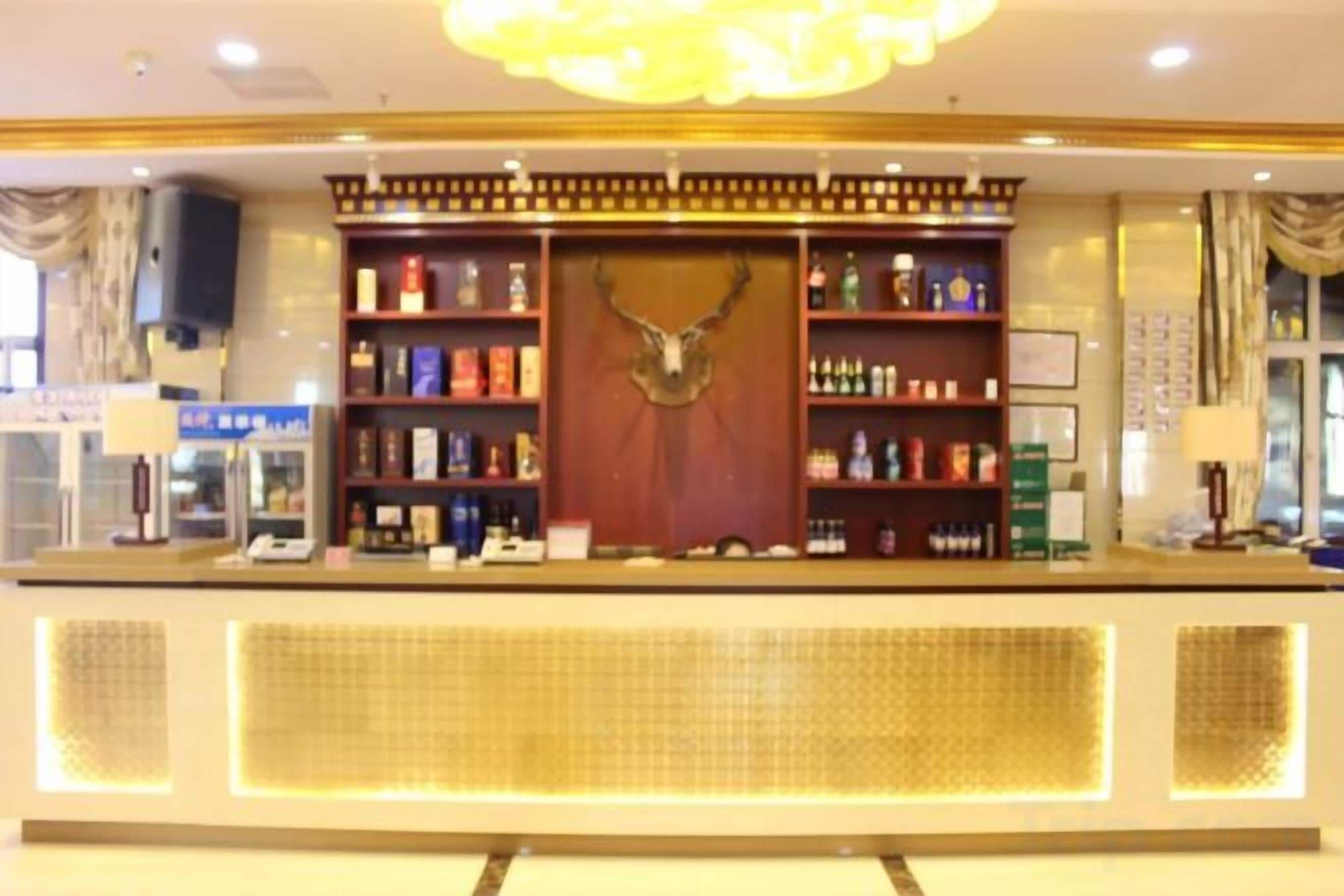 A reception area with a counter, shelves with various items, and a decorative wall piece.