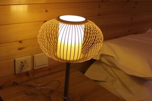 Luminária com design esférico sobre uma superfície de madeira.