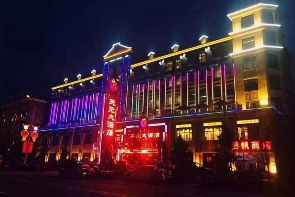 A hotel with a prominent vertical sign, multiple floors, and illuminated windows. - Tianyuan Hotel (Ergun)