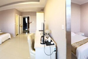 A hotel room with a bed, a desk with a lamp, a chair, and a television. - Tianyuan Hotel (Ergun)